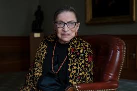 Picture of Ruth Bader Ginsberg seated. She wears a floral cardigan.