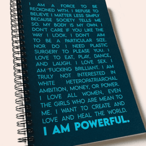 A blue spiral notebook titled "I AM POWERFUL Journal (Spicy Edition)," featuring a motivational quote in white text. The quote discusses self-confidence, body positivity, and empowerment, concluding with the statement "I am powerful.