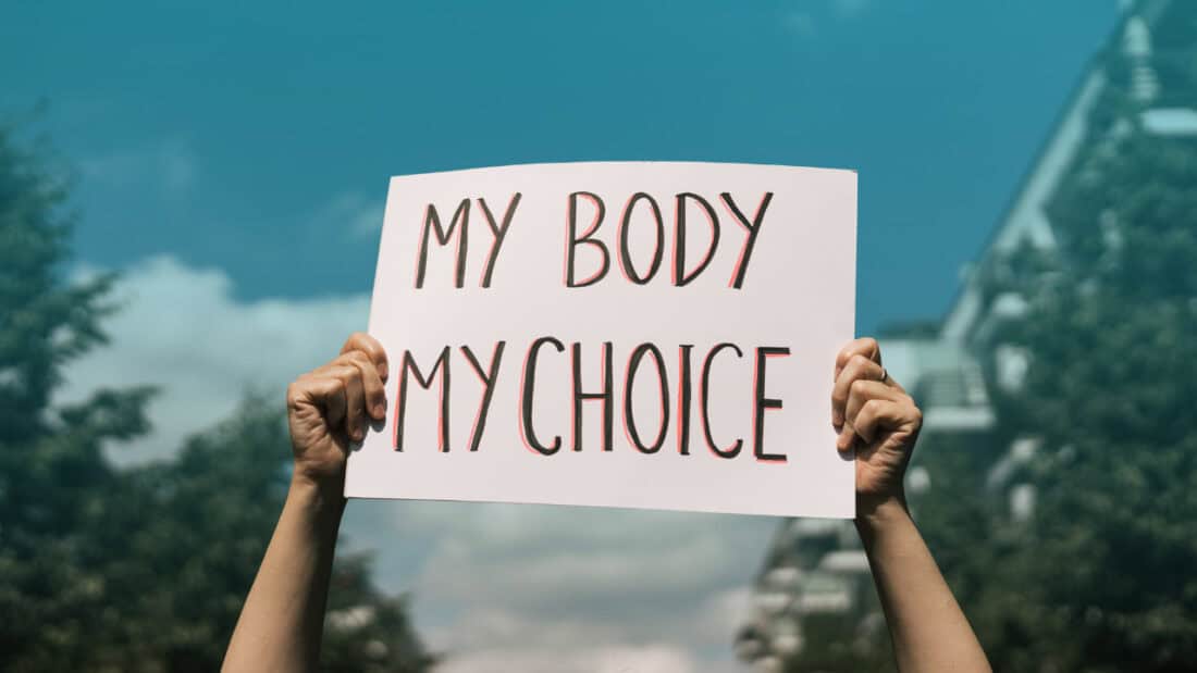 Hands holding a "My Body My Choice" sign