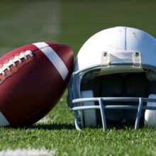 Football and helmet on field