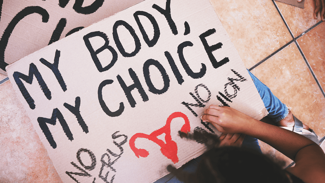 Person creating "My Body, My Choice" protest sign